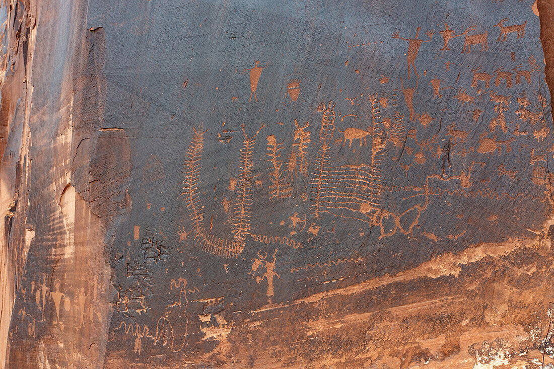 Historische Ute-Indianer und prähistorische Petroglyphen der Fremont-Kultur an einer Sandsteinwand in der Nähe von Moab, Utah.