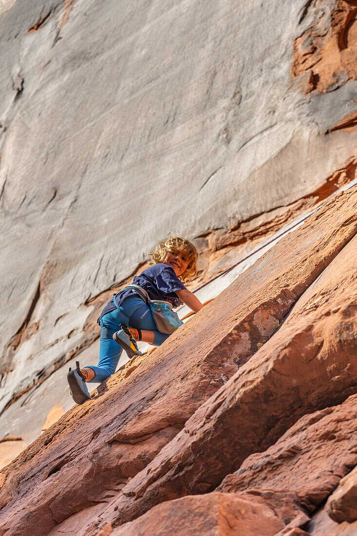 Ein 6-jähriger Junge lernt im Hunter Canyon in der Nähe von Moab, Utah, das Klettern.