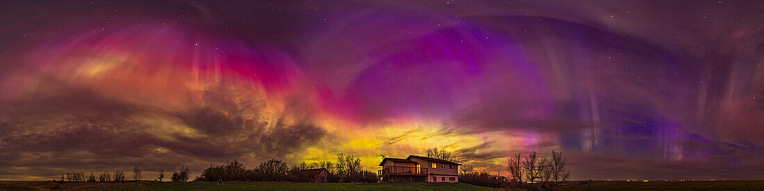 This is a 300º panorama of the May 10/11, 2024 great aurora display, when the Kp Index reached 8 this night bringing aurora to as far south as the southern U.S. Here, from my home in rural southern Alberta, Canada (latitude 51° N) we saw curtains strongly colored green and red from oxygen, but also pink and blue from nitrogen, with the latter colors unusually strong with pinks visible to the naked eye and purples and blues to the camera.