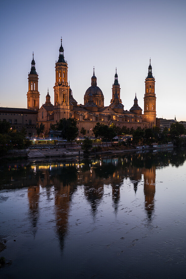 Cathedral-Basilica of Our Lady of the Pillar reflected on the Ebro River at sunset, Zaragoza, Spain