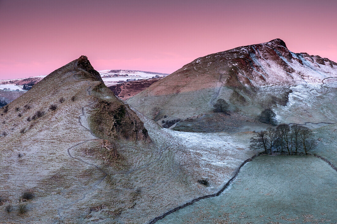 Das erste Licht der Morgendämmerung beleuchtet die Gipfel von Parkhouse und Chrome Hills im Winter, Peak District National Park, Derbyshire, England, Vereinigtes Königreich, Europa