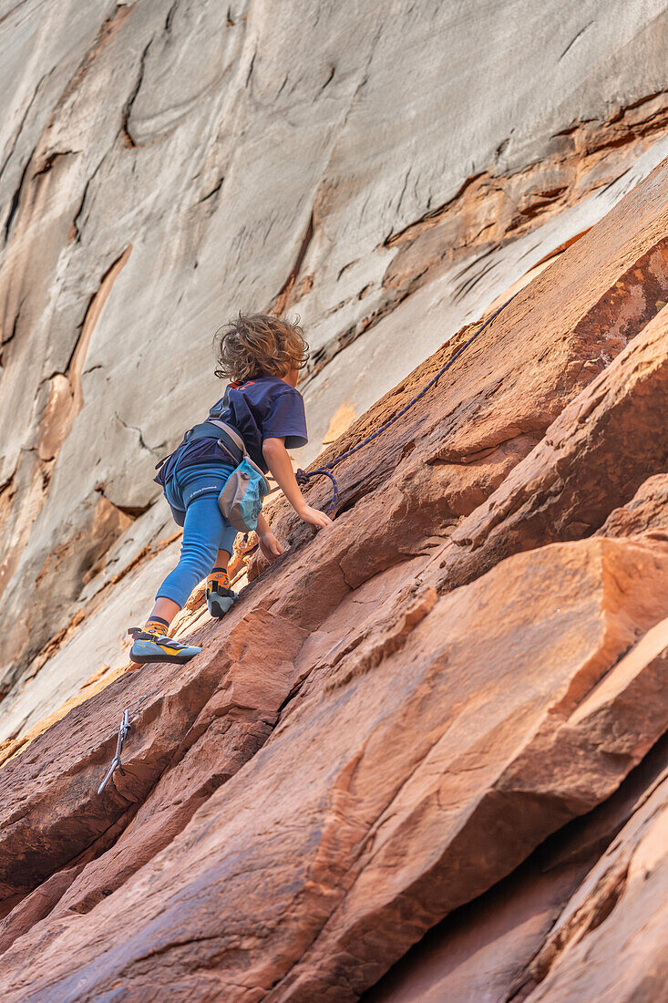 Ein 6-jähriger Junge lernt im Hunter Canyon in der Nähe von Moab, Utah, das Klettern.