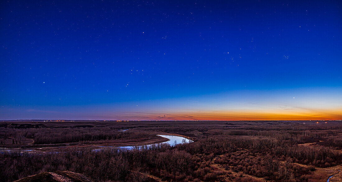 Thiis is a panorama of Orion and the winter stars setting into the evening twilight spring sky on April 19, 2024, in their last evening's appearance for the year.