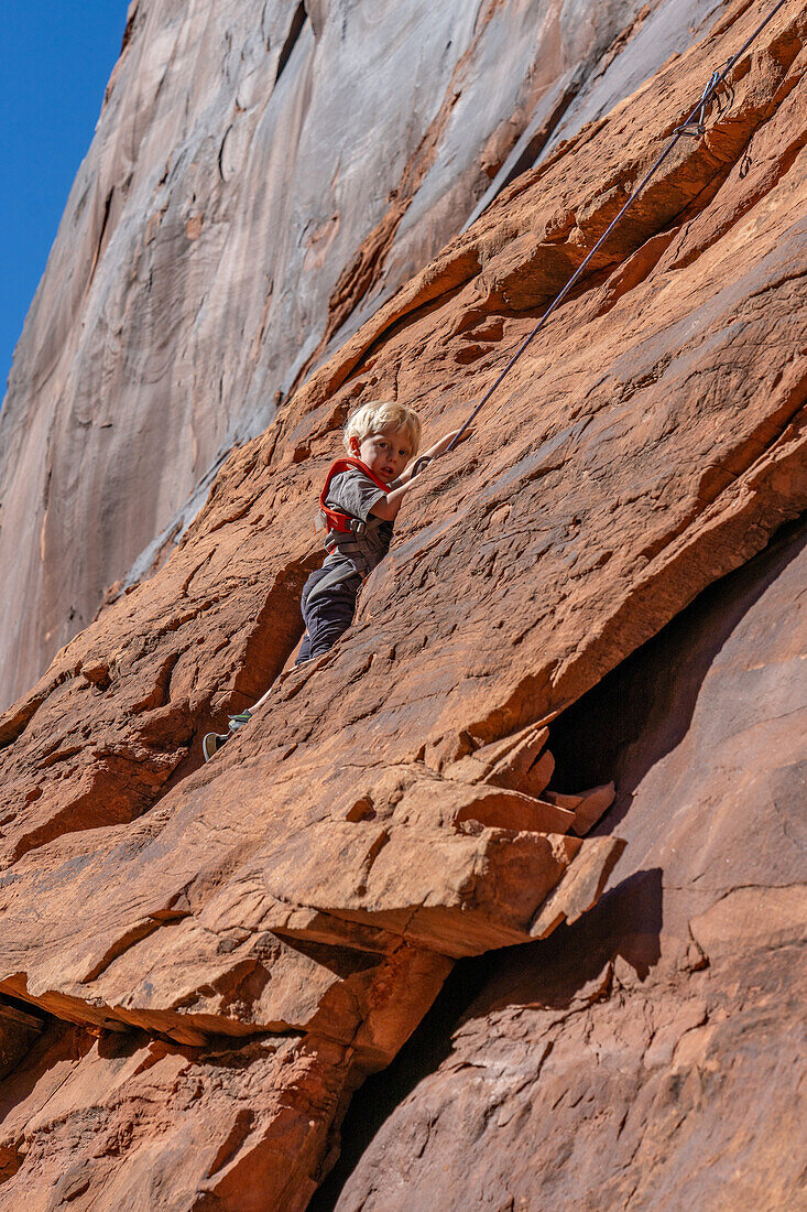 A young boy, age 3, learning to rock climb in Hunter Canyon near Moab, Utah.