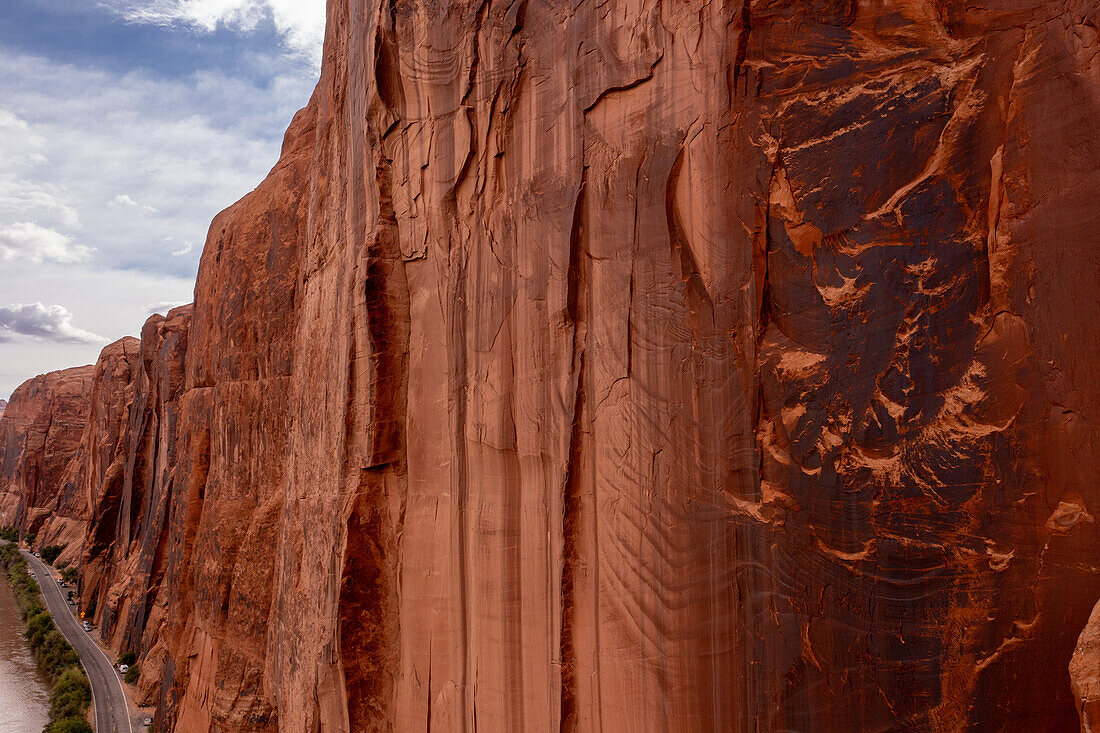 Aerial view of the Wingate Cliffs along Hwy 279 along the Colorado River near Moab, Utah. Note the parked vehicles of the rock climbers along Wall Street.