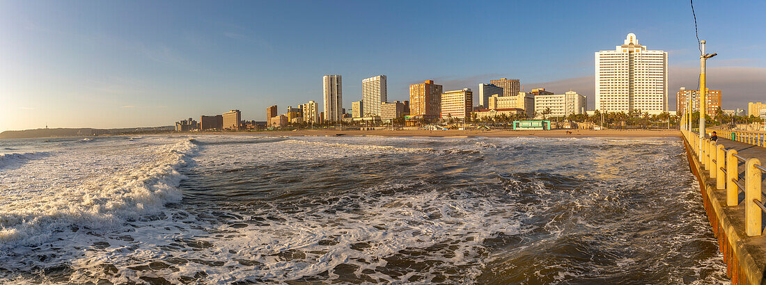 Blick auf Strandpromenade, Strand und Hotels vom Pier im Indischen Ozean bei Sonnenaufgang, Durban, Provinz KwaZulu-Natal, Südafrika, Afrika