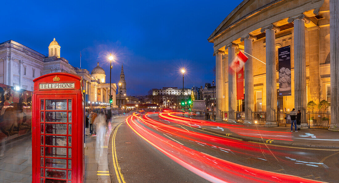 View of red telephone box and Trafalgar Square at dusk, Westminster, London, England, United Kingdom, Europe