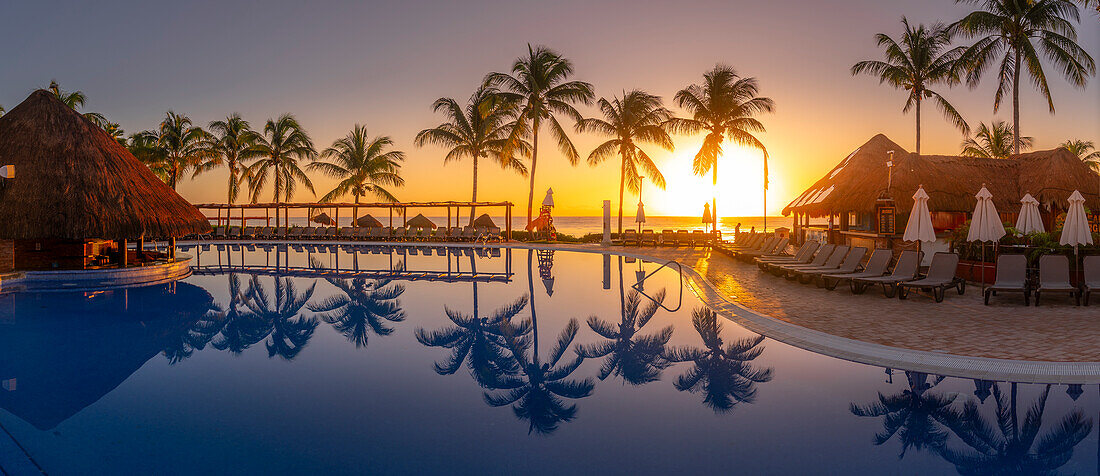 View of sunrise and palm tree reflections in hotel pool near Puerto Morelos, Caribbean Coast, Yucatan Peninsula, Mexico, North America