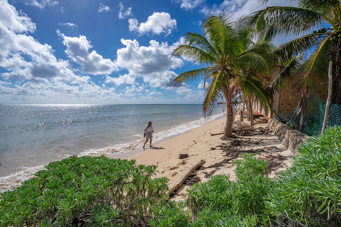 Blick auf eine Frau, die am Strand bei Puerto Morelos spazieren geht, Karibikküste, Halbinsel Yucatan, Mexiko, Nordamerika