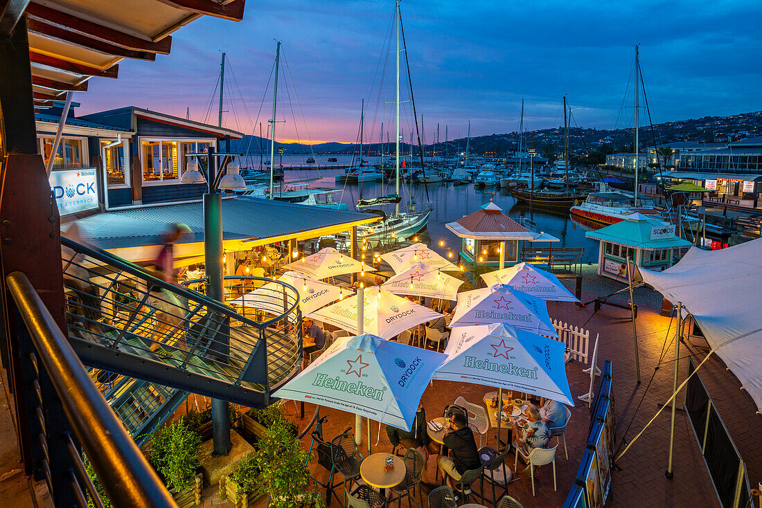 View of boats and restaurants at Knysna Waterfront at dusk, Knysna, Western Cape Province, South Africa, Africa