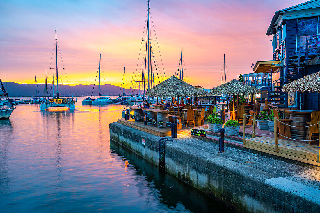 Blick auf den goldenen Sonnenuntergang, Boote und Restaurants an der Knysna Waterfront, Knysna, Westliche Kap-Provinz, Südafrika, Afrika