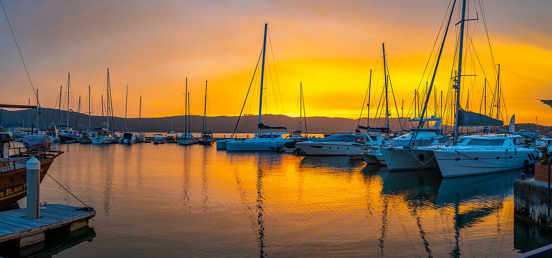 Blick auf einen goldenen Sonnenuntergang und Boote an der Knysna Waterfront, Knysna, Westliche Kap-Provinz, Südafrika, Afrika