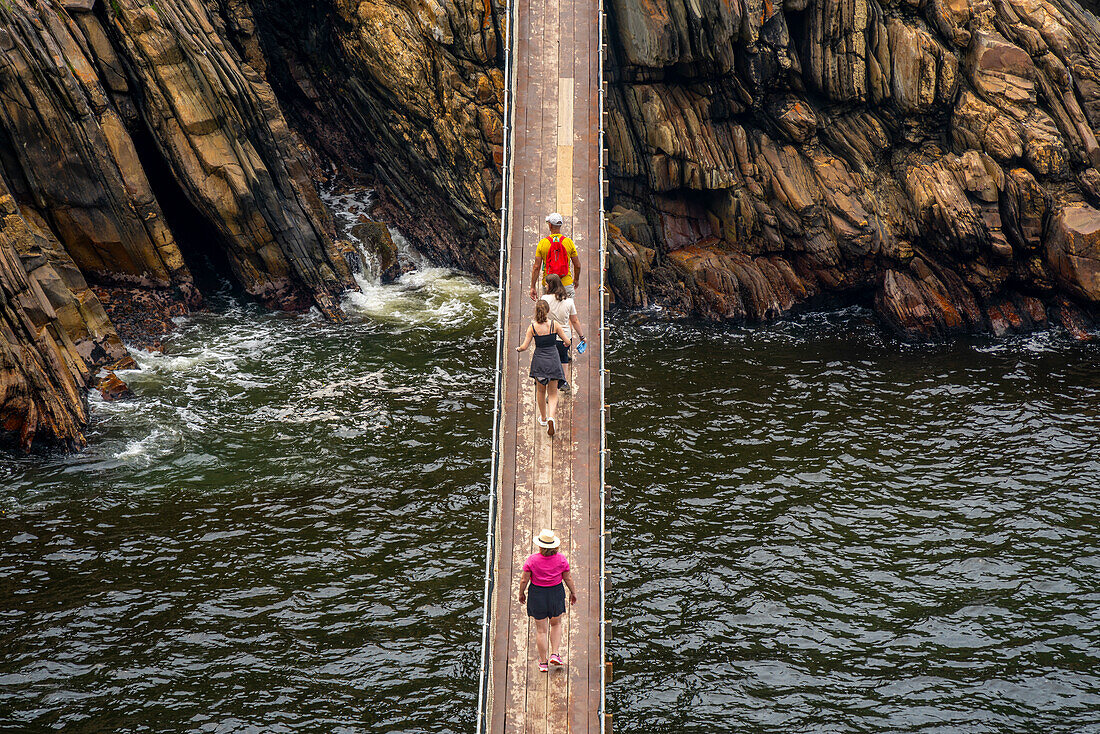 Blick auf Menschen, die eine Hängebrücke am Storms River überqueren, Tsitsikamma National Park, Garden Route National Park, Südafrika, Afrika