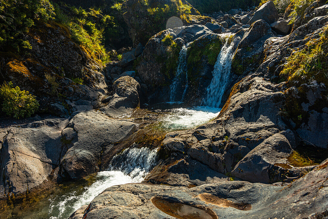 Wilkies Pools, warm sunlight on waterfalls in Mount Taranki National Park, North Island, New Zealand, Pacific