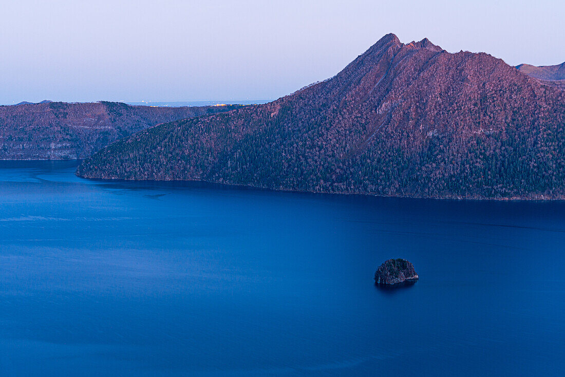 Ruhiges violettes Abendlicht, von blauer Stunde, tiefblauer Mashu-See in einem Krater, Akan Mashu Nationalpark, Hokkaido, Japan, Asien