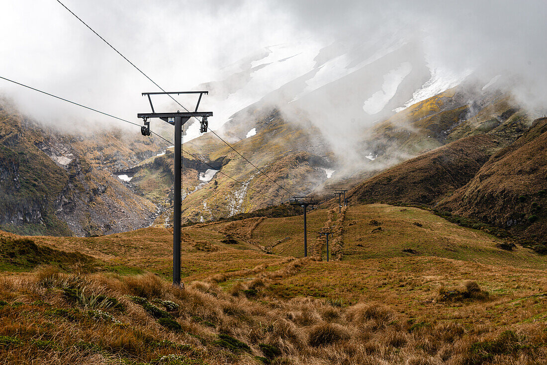 Grassy fields in front of the towering slopes of Mount Taranaki, electric grid, North Island, New Zealand, Pacific