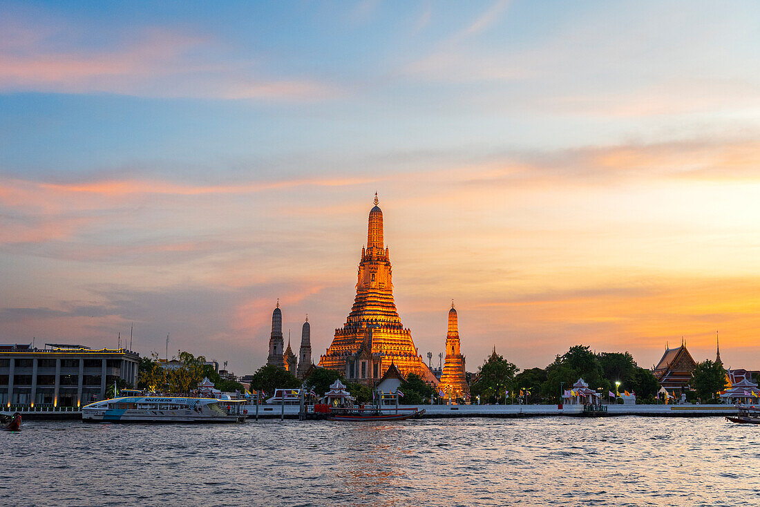 Wat Arun (Tempel der Morgenröte) entlang des Chao Phraya Flusses bei Sonnenuntergang, Bangkok, Thailand, Südostasien, Asien