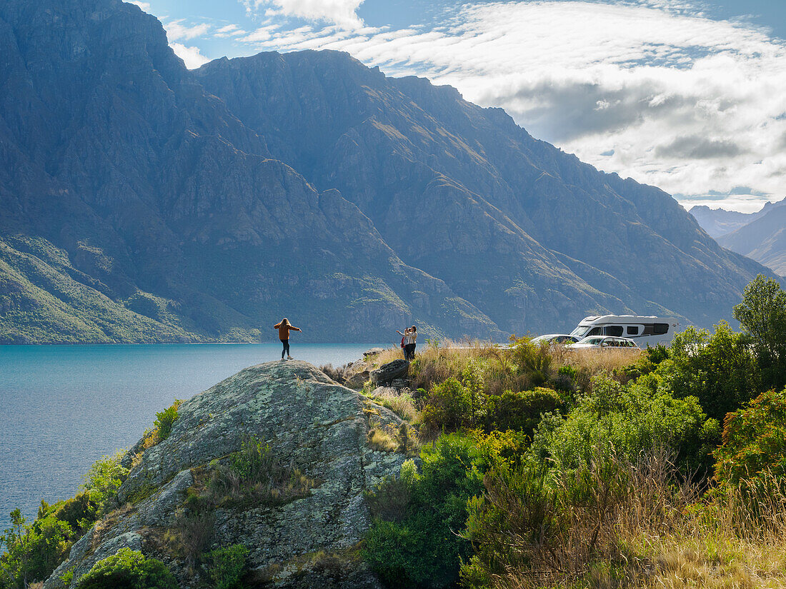 Posing for photos with mountains and Lake Wakatipu near Queenstown, Otago, South Island, New Zealand, Pacific