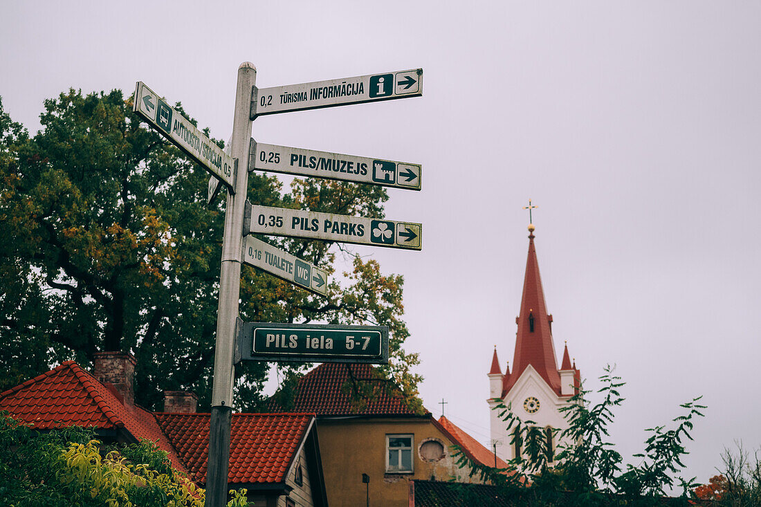 Signpost and St. John's Church in the Medieval Cesis Old Town, Cesis, Latvia, Baltics, Europe