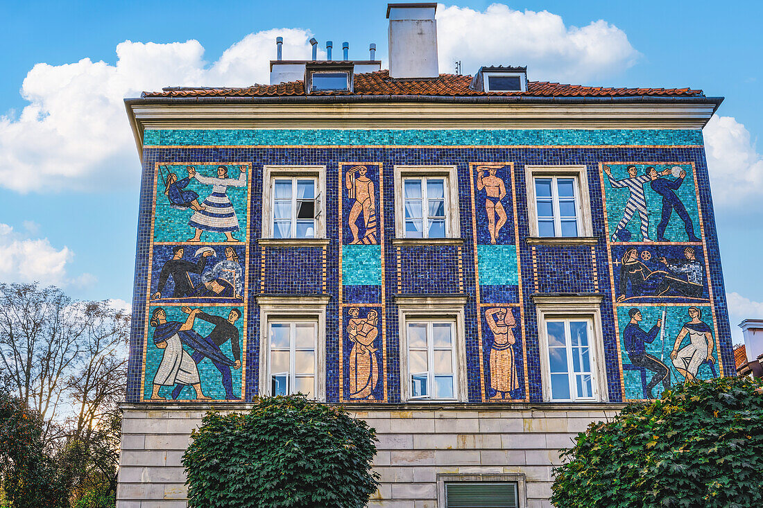 Day low angle view of a traditional roof tiled house decorated with vivid color mosaics depicting human figures in the Old Town, Warsaw, Poland, Europe