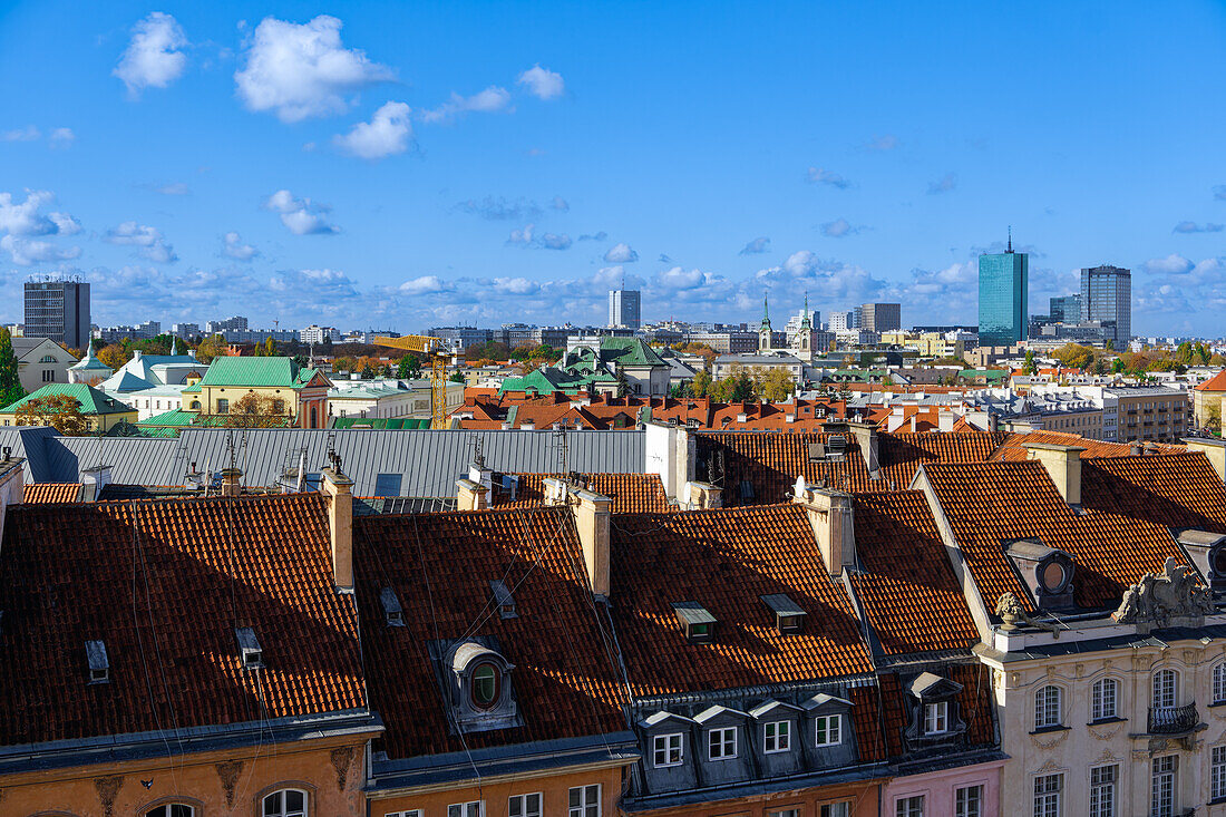 Panoramablick auf die Skyline der Stadt mit traditionellen Flachdachziegelhäusern und modernen Wolkenkratzern unter blauem Himmel mit Wolken, Warschau, Polen, Europa