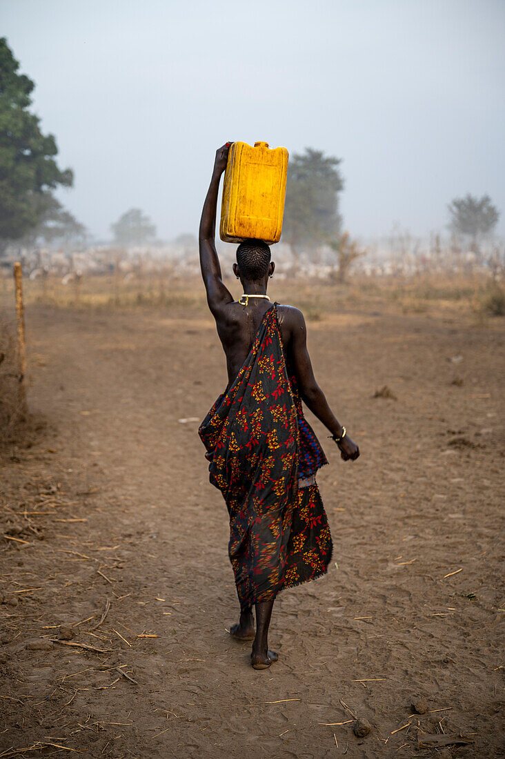 Mundari-Frau mit Wasserkanister auf dem Kopf, Mundari-Stamm, Südsudan, Afrika