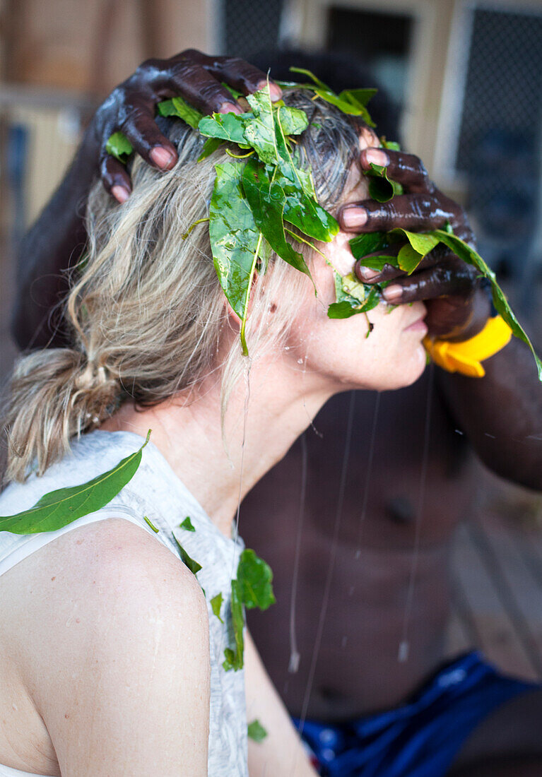 Aborigine Yolngu-Älterer, der lokale Pflanzen auf Sandbisswunden aufträgt, East Arnhem Land, Northern Territory, Australien, Pazifik