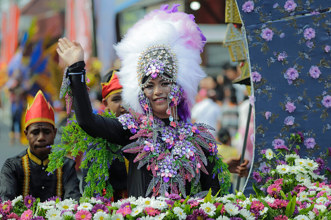 Winkende Frau in Kostüm bei der jährlichen Parade des Internationalen Blumenfestes von Tomohon, Nordsulawesi, Sulawesi, Indonesien, Südostasien, Asien