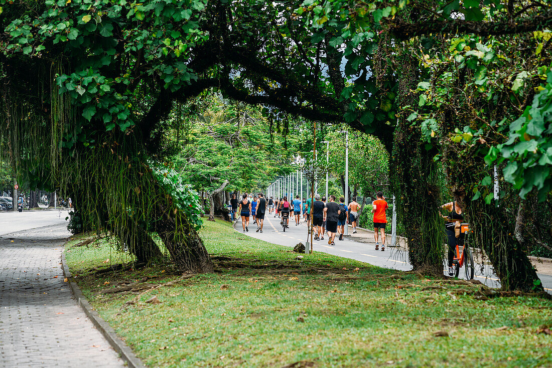 Menschen spazieren auf dem Fußgängerweg entlang der Lagoa Rodrigo de Freitas, Rio de Janeiro, Brasilien, Südamerika