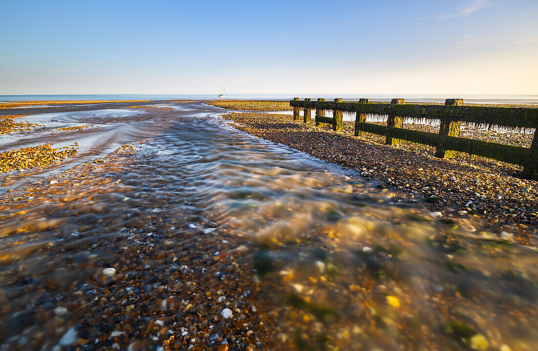 Ein Boot vor dem Strand von Cuckmere Haven bei Sonnenuntergang, East Sussex, England, Vereinigtes Königreich, Europa