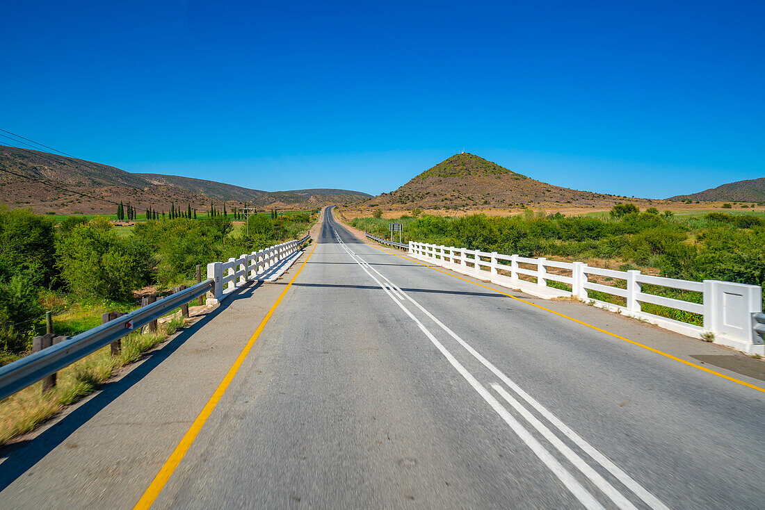 Blick auf die Straße R62 und die grüne Berglandschaft zwischen Zoar und Calitzdorp, Südafrika, Afrika