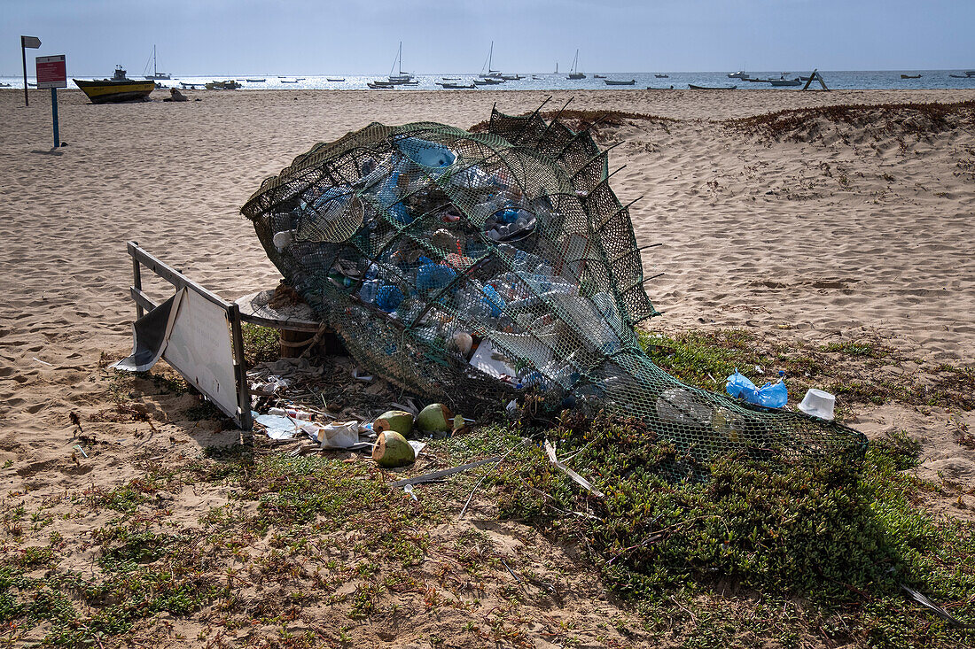 Netz in Form eines Fisches voll mit Plastikbehältern und Plastikmüll, aus dem zusätzliches Plastik herausläuft, Praia de Santa Maria Beach, Santa Maria, Sal, Kapverdische Inseln, Atlantik, Afrika