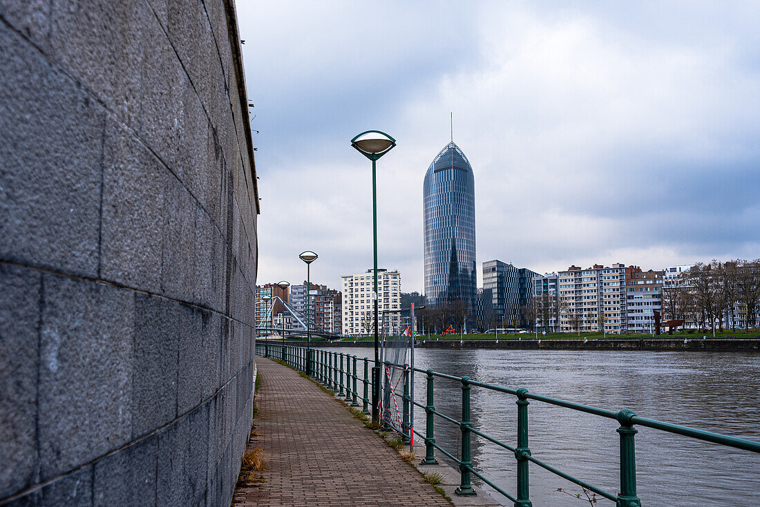 Path along the River Maas, looking along the walkway to La Tour des Finances de Leige (Tour Paradis), Liege, Belgium, Europe