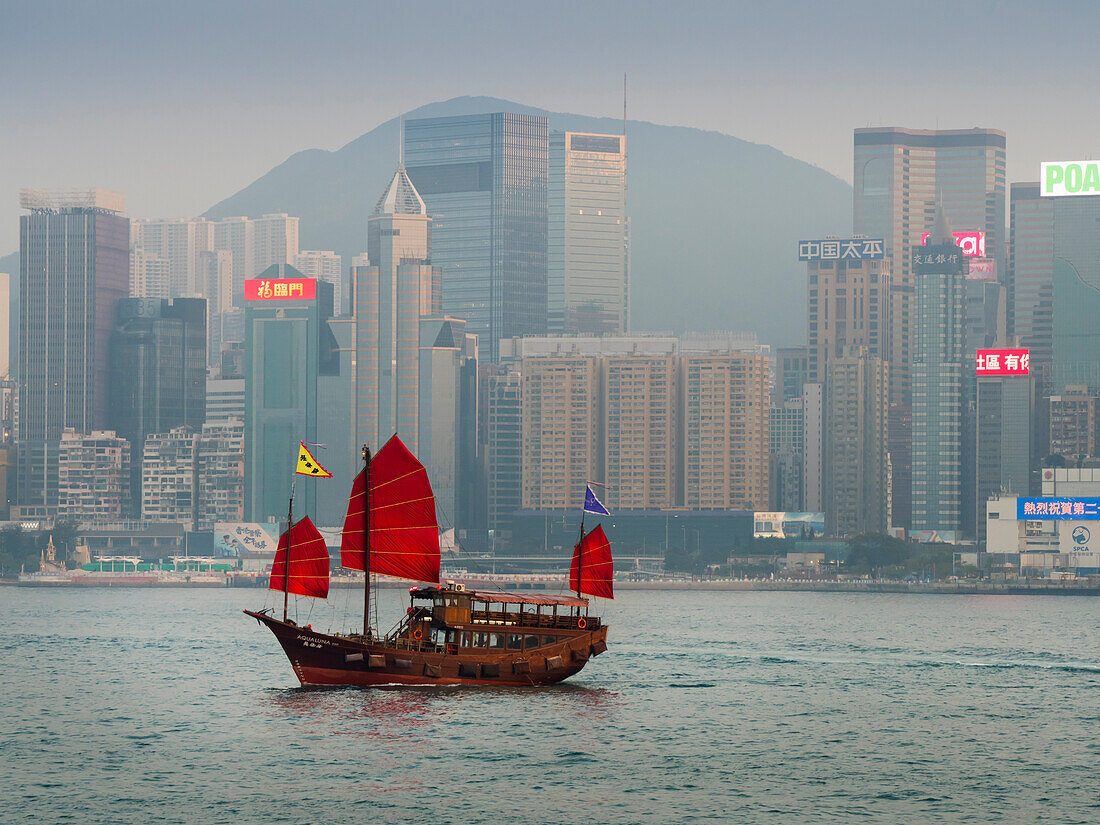 Dschunke mit roten Segeln, dahinter das Hafenviertel von Hongkong Island, Hongkong, China, Asien