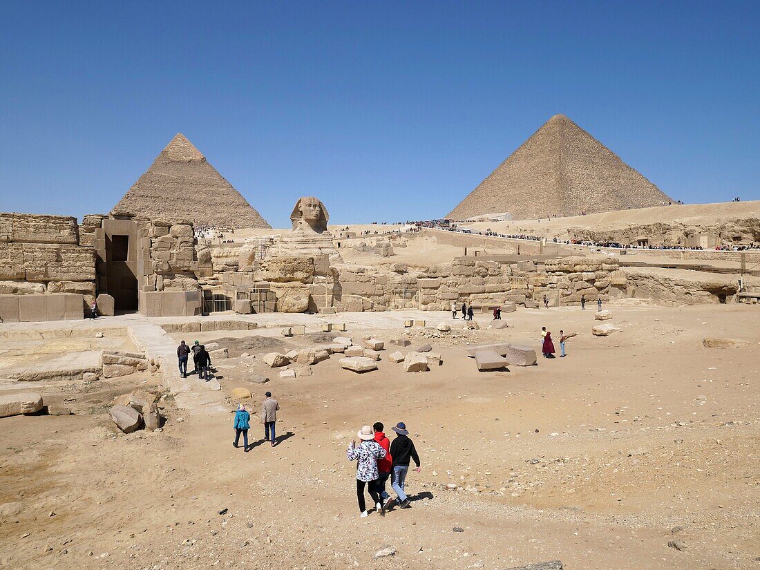 Egypt, Cairo, Giza, UNESCO World Heritage Site, Pyramids of Giza, Group of tourists in front of the Sphinx and Pyramids of Kheops, Khephren