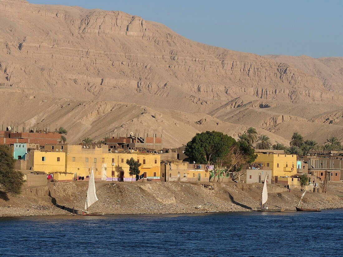 Ägypten, Oberägypten, Niltal, Dorf am Nilufer, gesehen von einem Kreuzfahrtschiff auf dem Nil bei Edfu