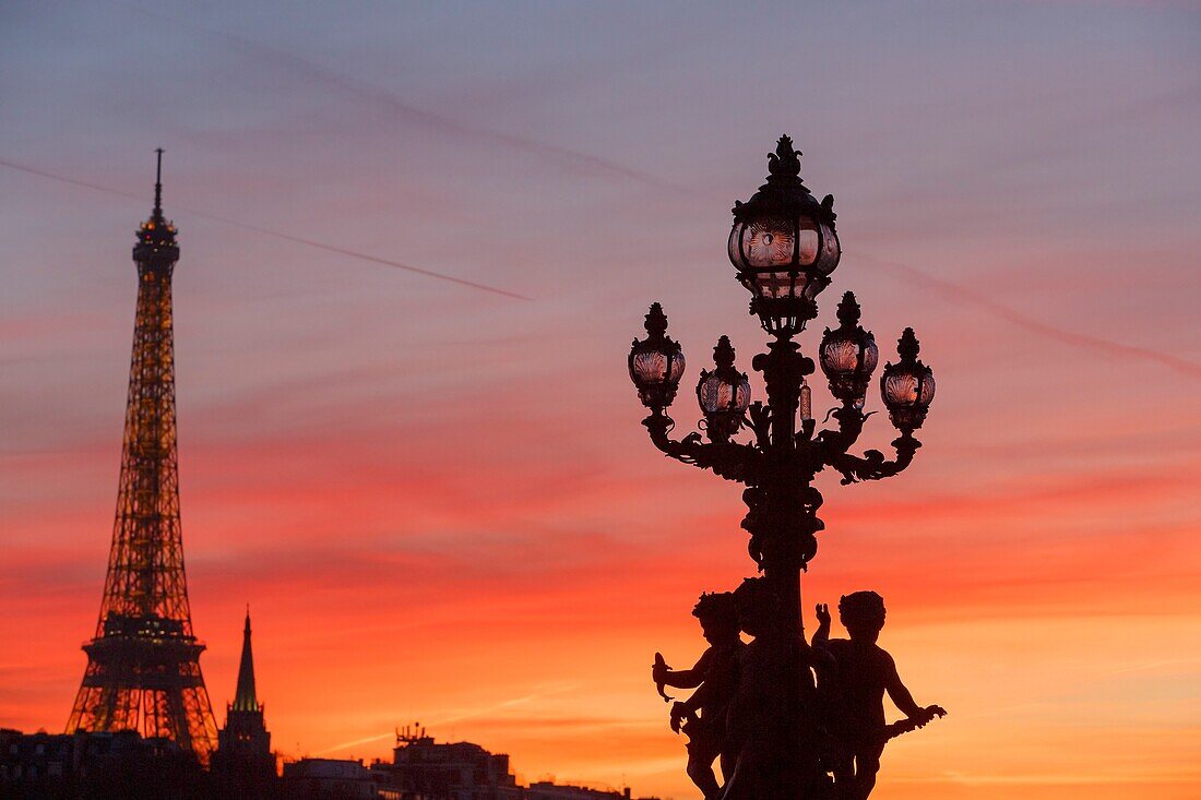 Frankreich, Paris, von der UNESCO zum Weltkulturerbe erklärtes Gebiet, die Putten, die eine Straßenlaterne von Henri Gauquie auf der Pont Alexandre III (Brücke Alexandre der Dritte) tragen, und der Eiffelturm im Hintergrund