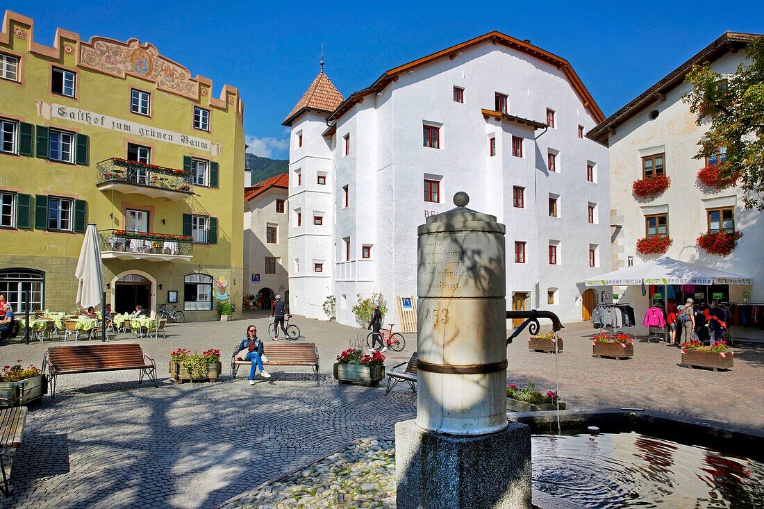 Italien, Autonome Provinz Bozen, Brunnen auf einem von mittelalterlichen Häusern umgebenen Platz in einem der schönsten Dörfer Italiens