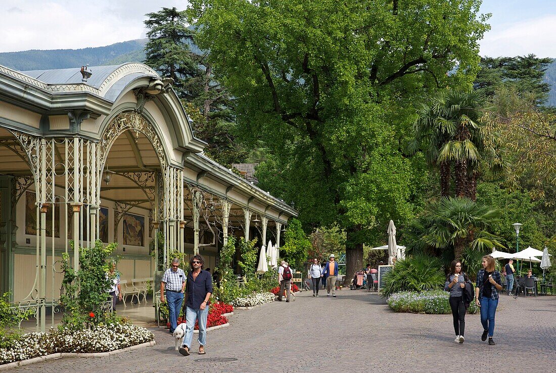 Italien, autonome Provinz Bozen, Meran, Spaziergänger auf der von Bäumen und Jugendstilbauten gesäumten Promenade Corso Libertad