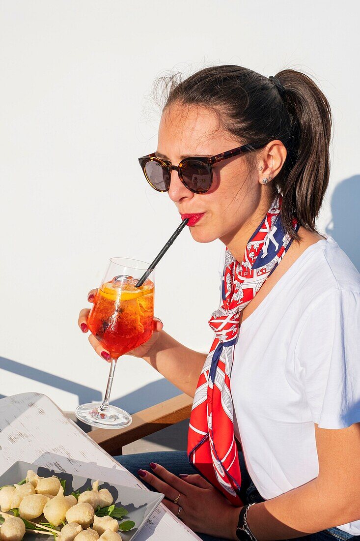 Italy, Campania, Naples area, Pozzuoli, young Italian woman drinking a spritz