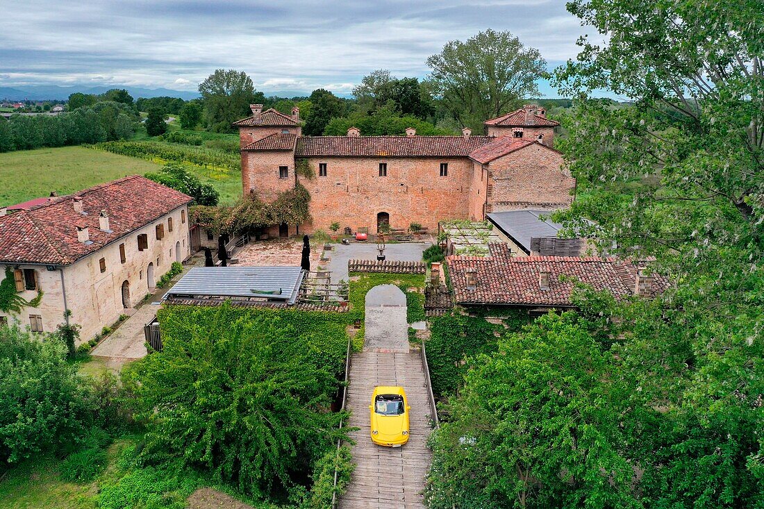 Italy, Emilia Romagna, Polesine Zibello near Parma, Antica Corte Pallavicina Hotel and restaurant, Alfa Romeo Duetto Spider yellow cabriolet (aerial view)