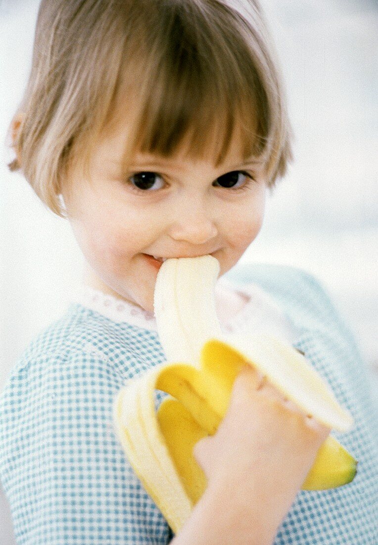 Little Girl Eating a Banana