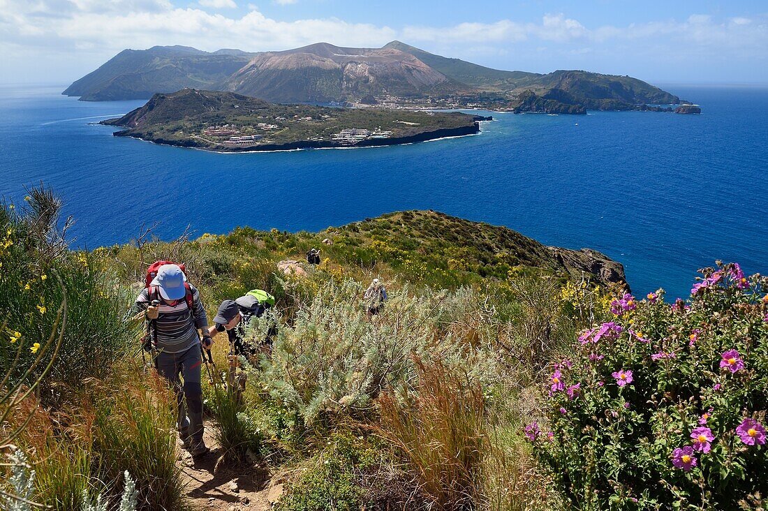 Italien, Sizilien, Äolische Inseln, von der UNESCO zum Weltkulturerbe erklärt, Insel Lipari, Wanderer auf dem Küstenweg und die Insel Vulcano im Hintergrund