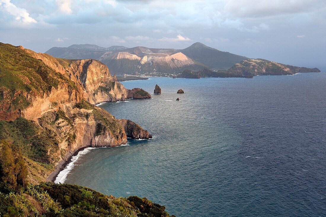 Italien, Sizilien, Äolische Inseln, von der UNESCO zum Weltkulturerbe erklärt, Insel Lipari, die Klippen der Südwestküste der Insel bei Quattrocchi mit Blick auf die Insel Vulcano im Hintergrund