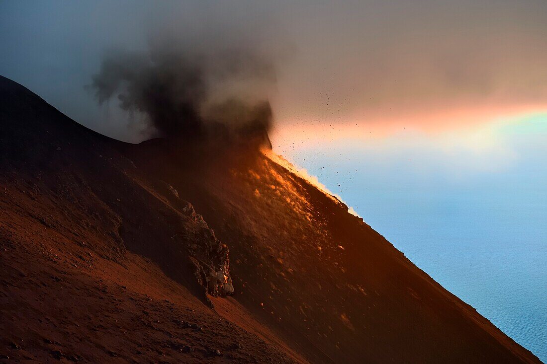 Italien, Sizilien, Äolische Inseln, von der UNESCO zum Weltnaturerbe erklärt, Insel Stromboli, Ausbruch und Projektion von Lavabomben an den Hängen des aktiven Vulkans bei Sonnenuntergang