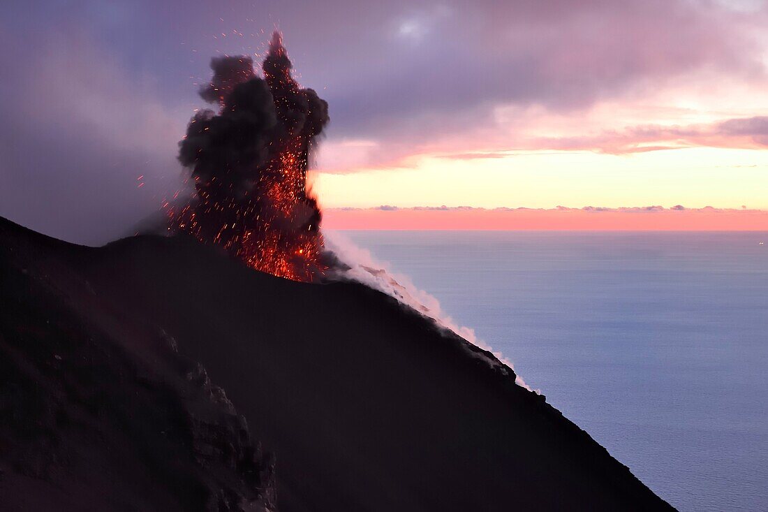 Italien, Sizilien, Äolische Inseln, von der UNESCO zum Weltnaturerbe erklärt, Insel Stromboli, Ausbruch und Projektion von Lavabomben an den Hängen des aktiven Vulkans bei Sonnenuntergang