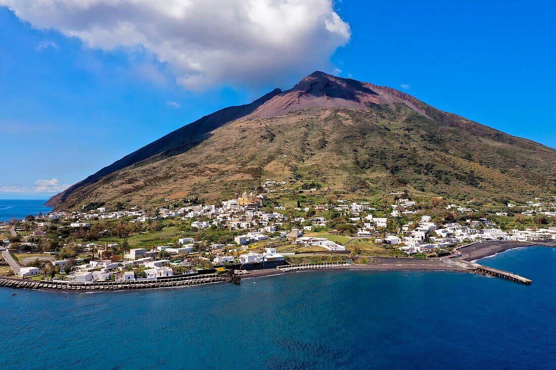 Italien, Sizilien, Äolische Inseln, von der UNESCO zum Weltkulturerbe erklärt, Insel Stromboli, der aktive Vulkan Stromboli über dem Dorf (Luftaufnahme)