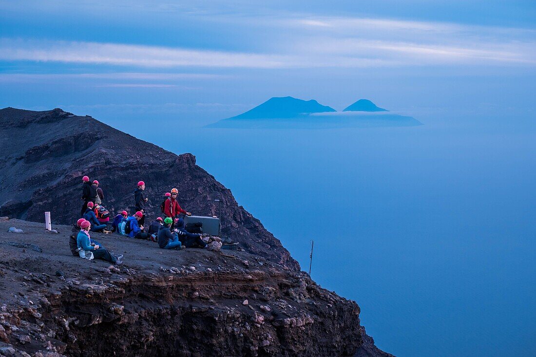 Italien, Sizilien, Äolische Inseln, Tyrrhenisches Meer, San Vincenzo, Vulkan Stromboli, Wanderer auf dem Gipfel 924 m und andere Inseln im Hintergrund