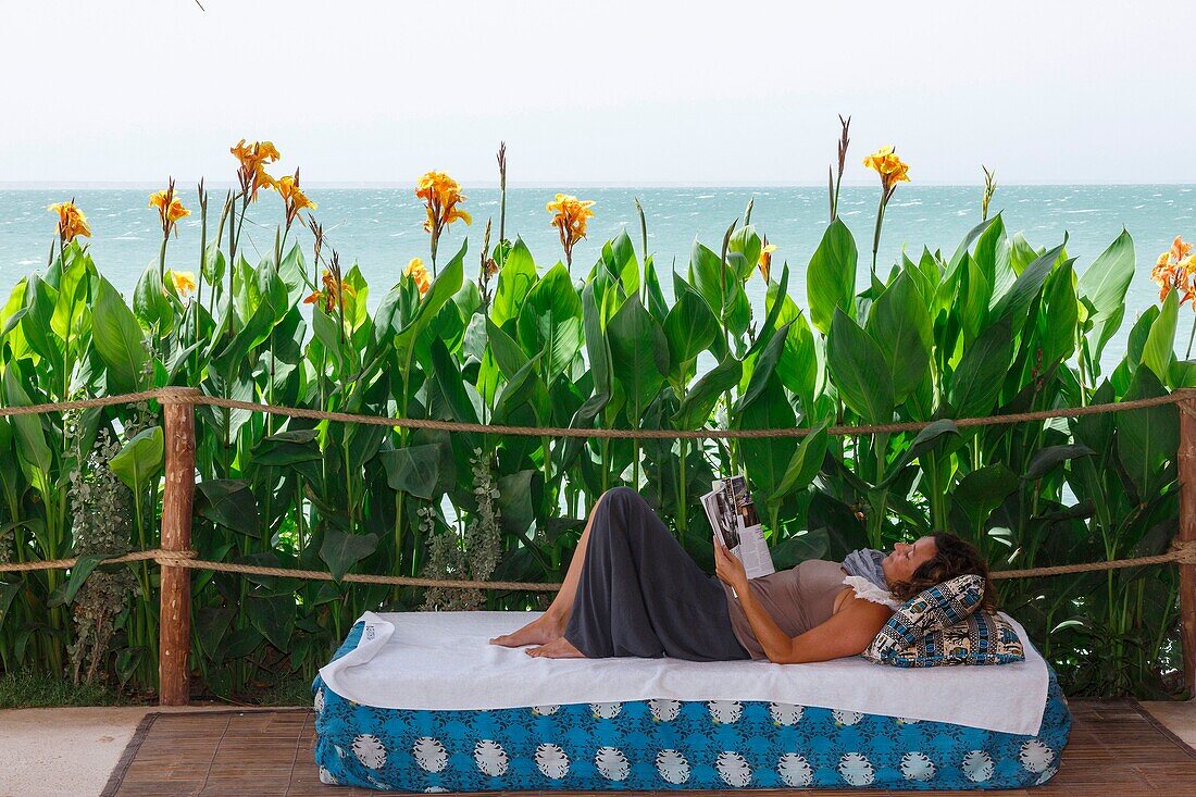 Marokko, Oued Ed-Dahab, Dakhla, La Crique Hotel, junge Frau ruht sich auf einer Terrasse am Meer aus