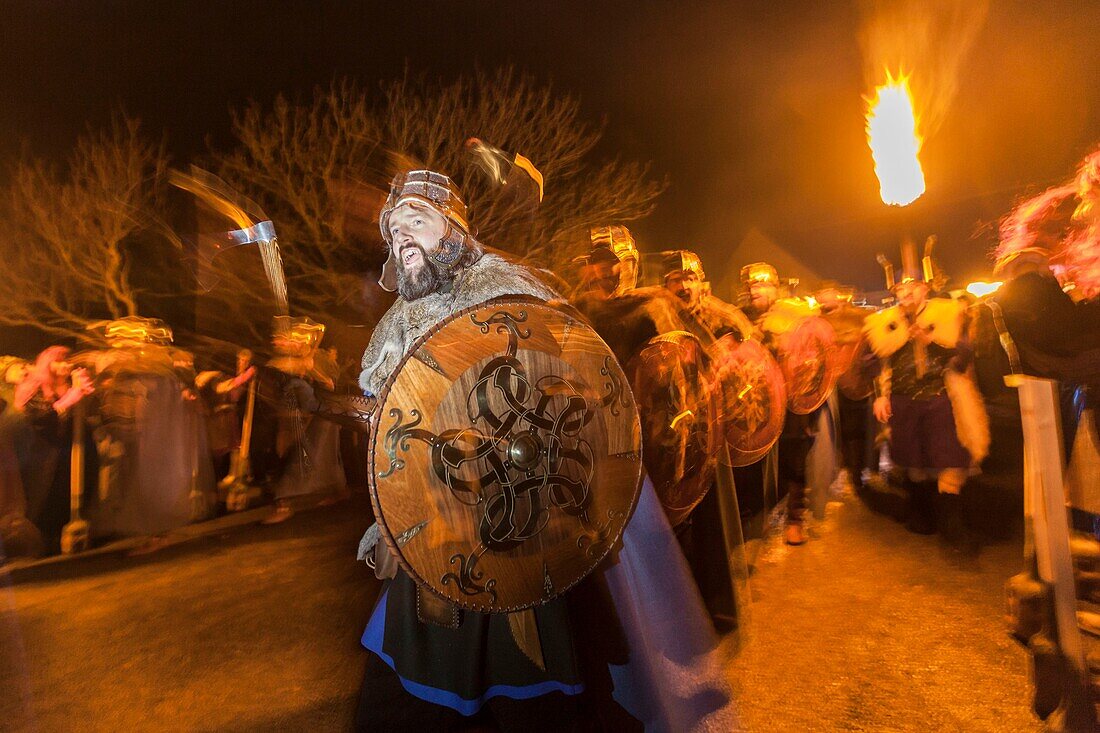 Vereinigtes Königreich, Schottland, Shetlandinseln, Festland, Lerwick, Up Helly Aa Festival, eine Gruppe von Guizern zieht zum Platz, wo das Wikinger-Langschiff in Brand gesetzt wird